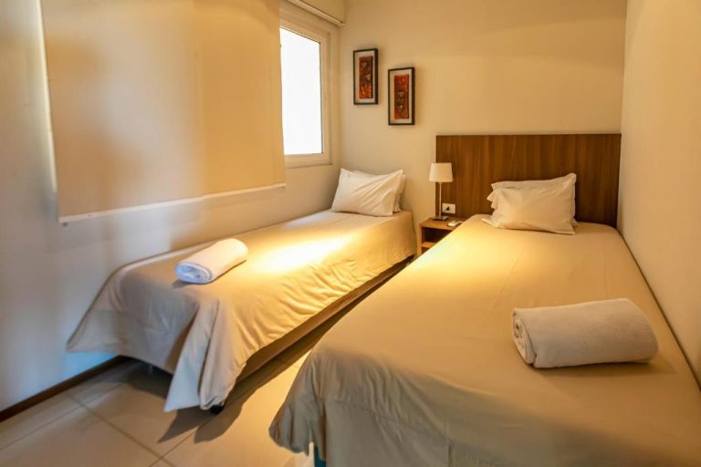 Habitación twin con dos camas individuales y toallas en Asunción Rent Suites Santa Teresa