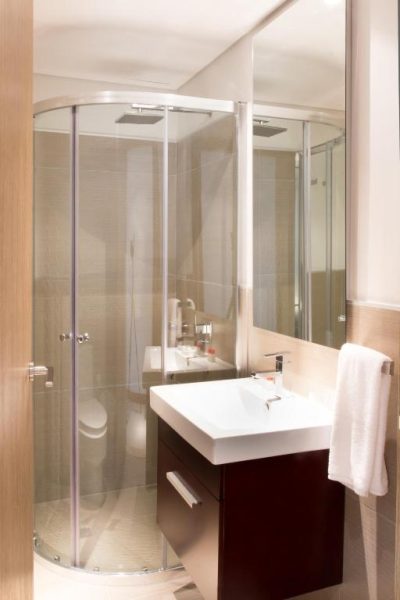 Baño moderno con ducha de cristal y lavabo en Asunción Rent Suites Santa Teresa