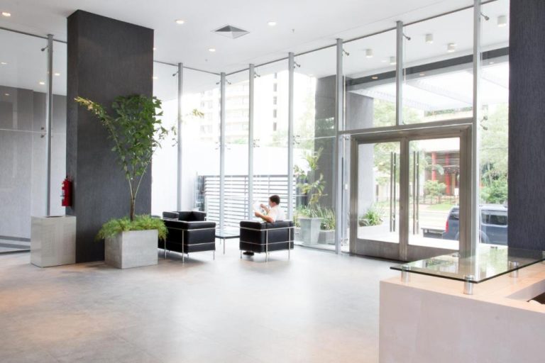 Lobby moderno con plantas naturales y zona de espera del Asunción Rent Suites Santa Teresa