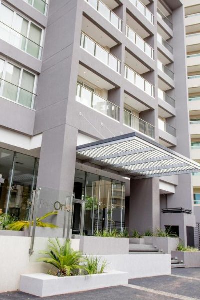 Fachada y entrada principal del Asunción Rent Suites Santa Teresa con jardines y marquesina moderna