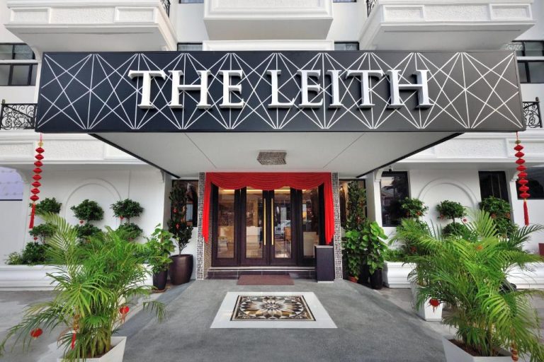Entrada principal del hotel The Leith con decoración tropical y marquesina negra con diseño geométrico