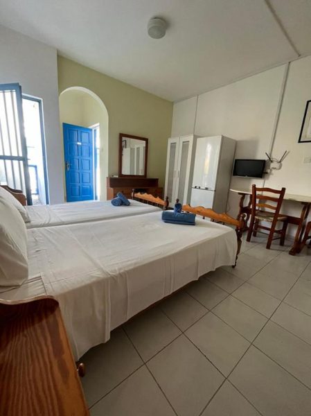 Habitación doble con cama amplia y puerta azul característica del Tasmaria Aparthotel