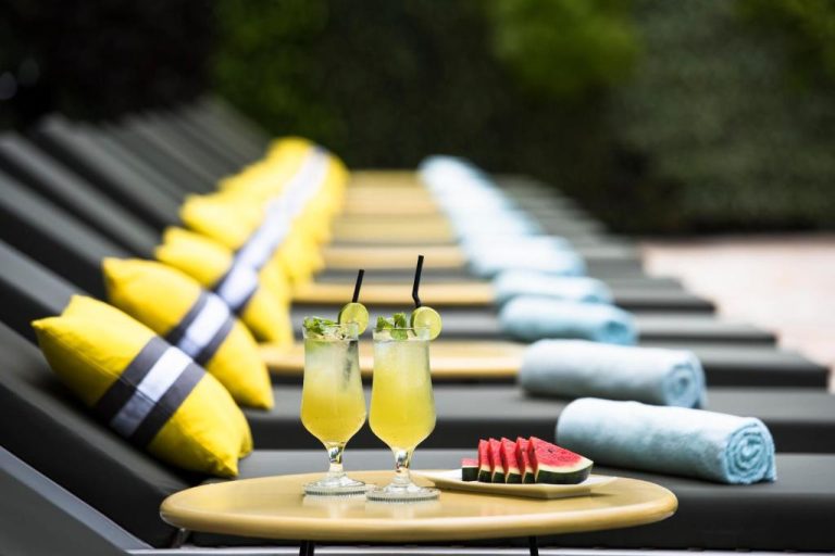 Cócteles de mojito y sandía fresca junto a tumbonas con cojines amarillos en Viroth's Hotel