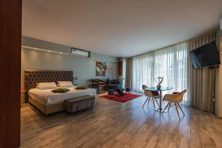 Suite amplia con cama doble y zona de estar en Shoshana Hotel Boutique