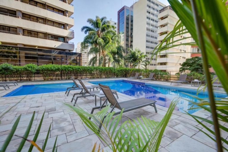 Piscina exterior con tumbonas y palmeras del Radisson São Paulo Paulista rodeada de edificios
