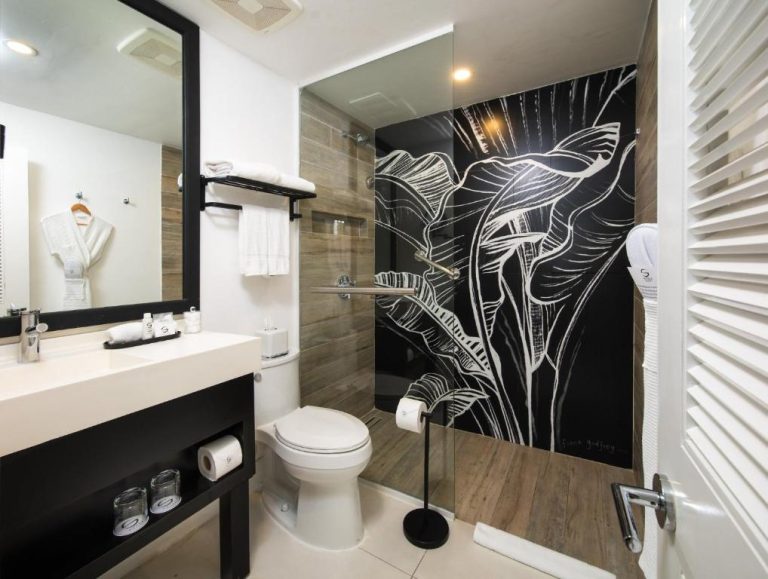 Baño de lujo con ducha y mural artístico de hojas tropicales en S Hotel Montego Bay Jamaica