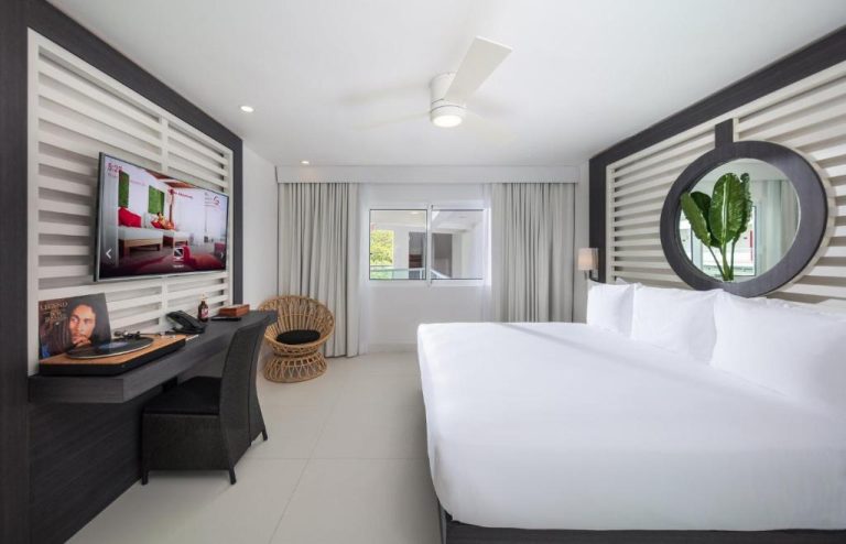 Habitación king de lujo con cama doble, TV y decoración moderna en S Hotel Montego Bay Jamaica