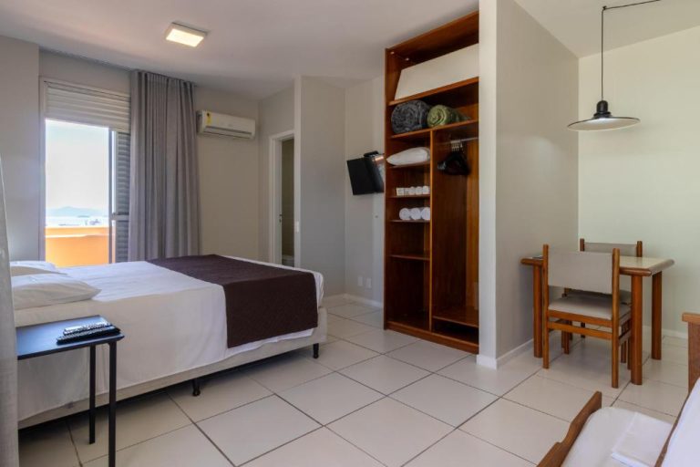 Habitación doble con armario de madera, televisión y mesa de trabajo en Rio Branco Hotel