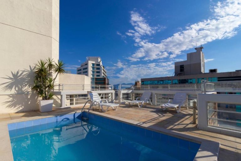Piscina exterior en terraza con tumbonas y vistas a la ciudad del Rio Branco Hotel