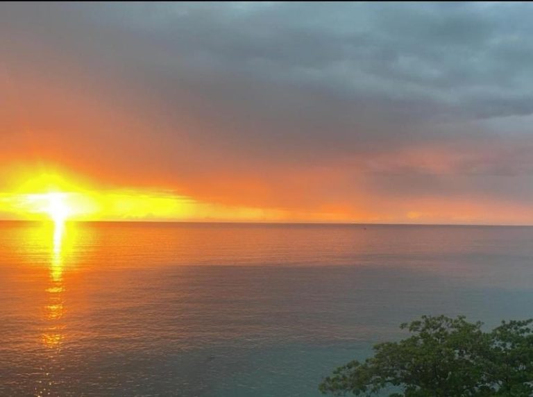 Espectacular atardecer sobre el mar visto desde el Hotel Villamar2 con cielo naranja y reflejo en el agua