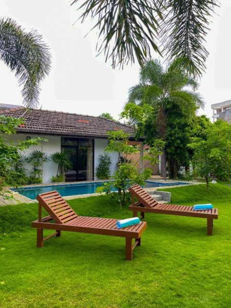 Piscina privada con tumbonas y jardín tropical en The Barns Villas and Restaurant