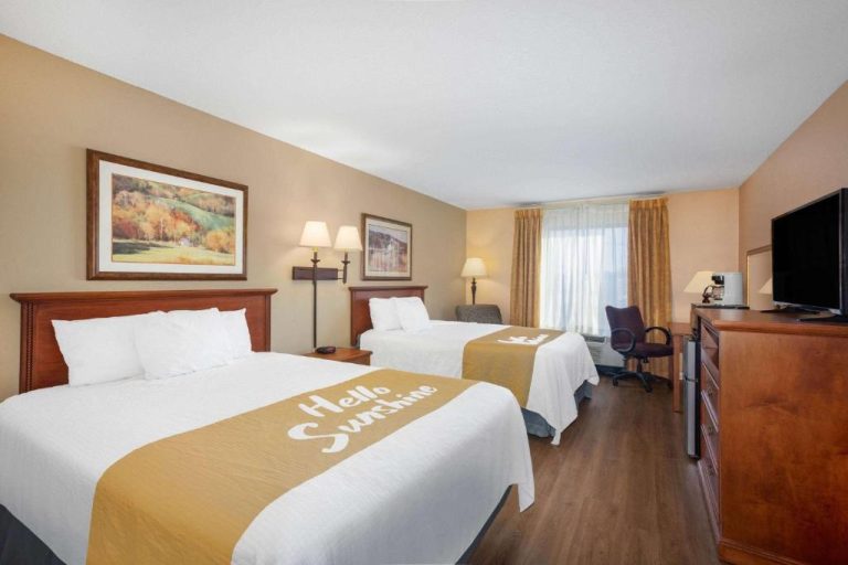 Habitación doble con dos camas queen y TV en Days Inn & Suites by Wyndham Cuba