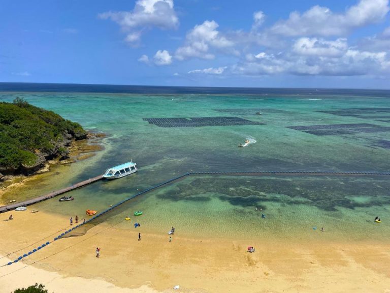 Playa cristalina con arrecife de coral y embarcadero del Hotel Monterey Okinawa Spa & Resort