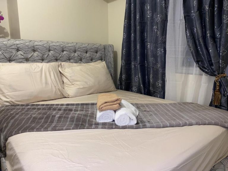 Habitación doble con cama matrimonial y toallas en apartamento Avida Riala IT Park Cebu
