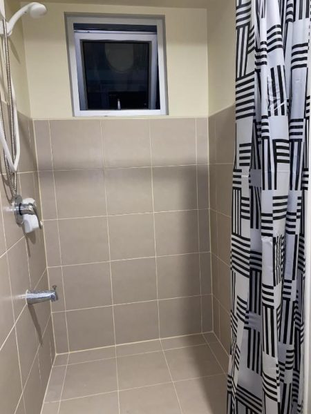 Ducha con azulejos beige y cortina en blanco y negro en apartamento Avida Riala IT Park Cebu