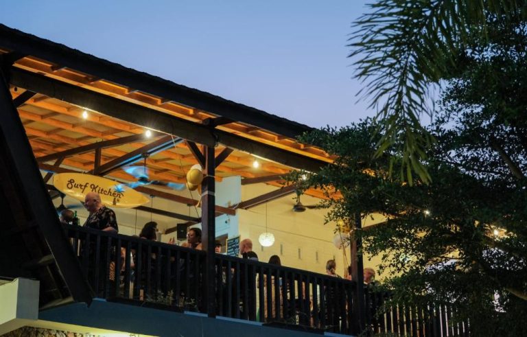 Terraza del restaurante Surf Kitchen en Bruga Boutique Hotel iluminada al atardecer con clientes