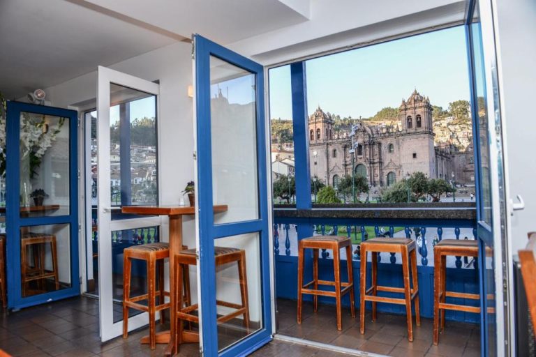 Balcón con taburetes y vistas a la Catedral del Cusco desde el Hotel Plaza de Armas Cusco