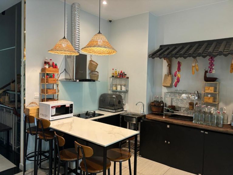 Cocina compartida con isla de mármol y decoración asiática en Green Inn Phu Quoc Hotel