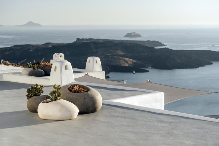 Terraza con maceteros de piedra y vistas a la caldera volcánica del mar Egeo en Belvedere Suites Santorini