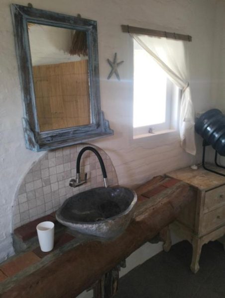 Baño rústico con lavabo de piedra natural y encimera de madera en SHAYA Cottage