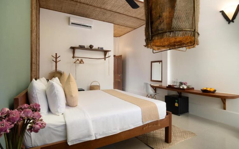 Habitación doble con decoración natural y cama king size en The Jungle Hotel con elementos de bambú y ratán