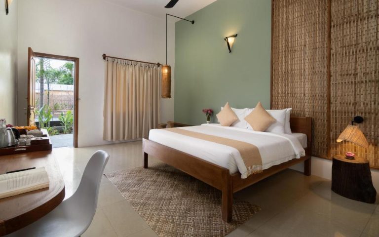 Habitación doble con decoración natural y bambú en The Jungle Hotel, cama de madera y jardín exterior