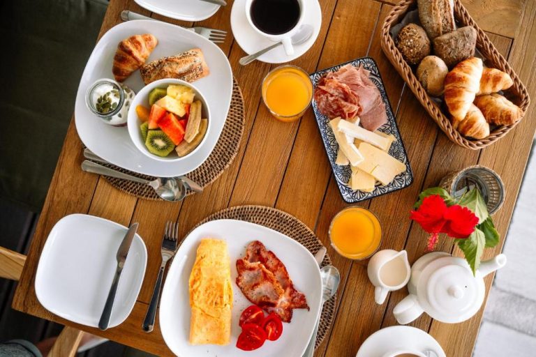 Desayuno continental con huevos, bacon, quesos, embutidos y zumo de naranja en The Bay Seychelles Boutique Hotel