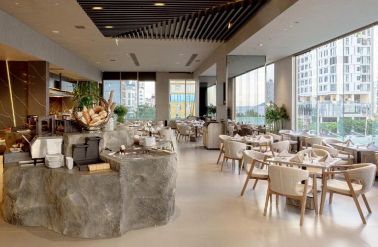 Restaurante con buffet de desayuno y vistas panorámicas a la ciudad en M Hotel Danang