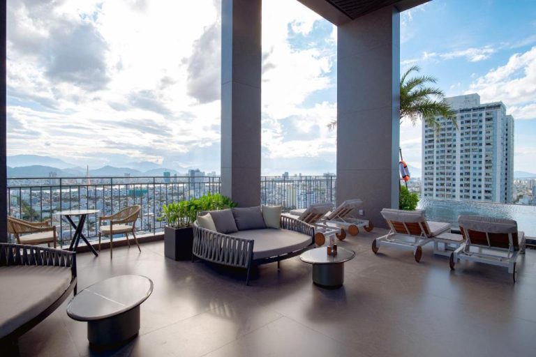 Terraza con piscina infinita y zona lounge del M Hotel Danang con vistas panorámicas a la ciudad