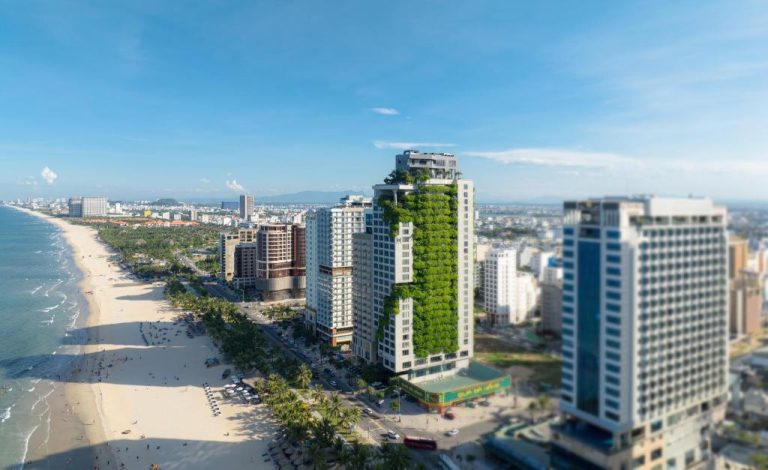 Vista aérea del M Hotel Danang con fachada verde frente a la playa de Da Nang, Vietnam