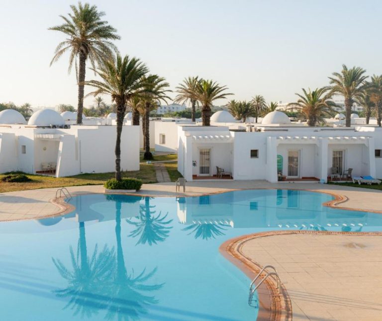 Piscina exterior con bungalows blancos y palmeras del One Resort Aqua Park en Túnez