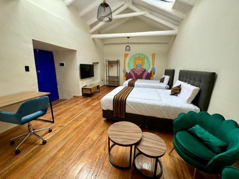 Habitación doble con suelo de madera y mural inca en Way Kap Hostel Cusco