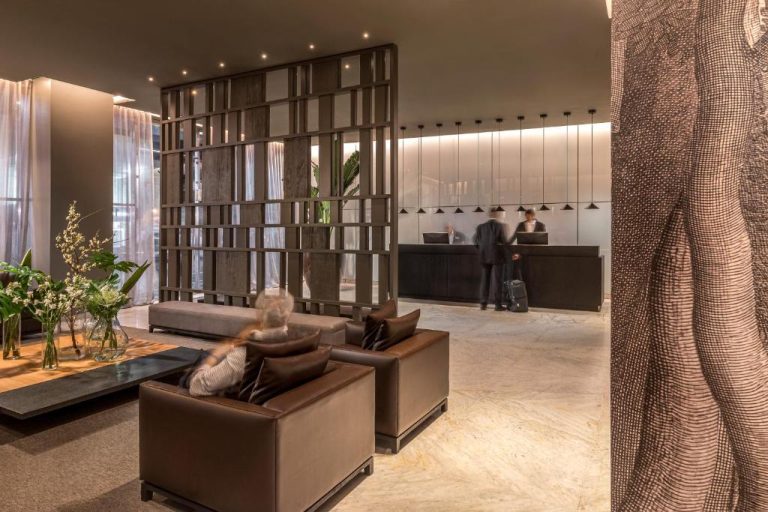 Elegante lobby con recepción y zona de descanso del Broadway Hotel & Suites con decoración moderna