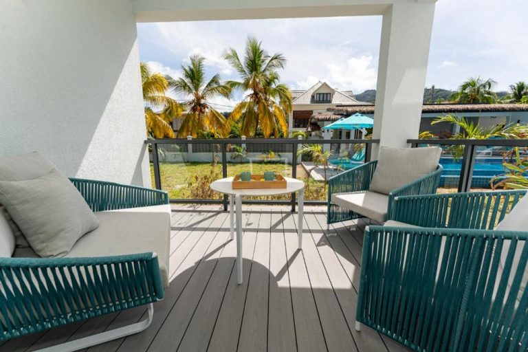 Terraza privada con sillones turquesa y vista a la piscina en Anse La Mouche Villas, Seychelles