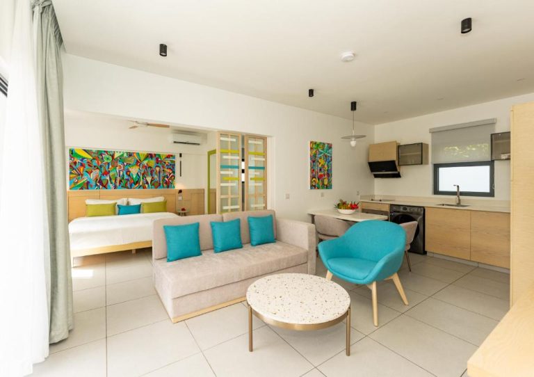 Suite con salón, cocina equipada y dormitorio en Anse La Mouche Villas con decoración tropical