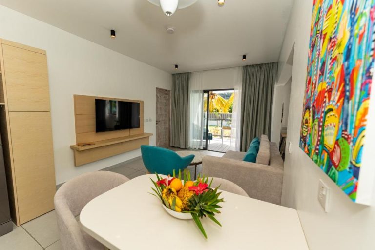 Salón moderno con cocina y terraza en Anse La Mouche Villas, decorado con arte tropical colorido