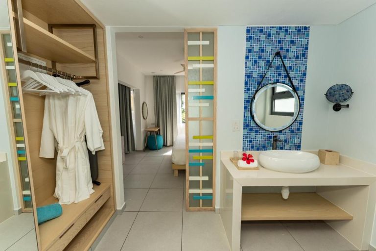 Baño y vestidor de lujo con mosaico azul y bañera sobre encimera en Anse La Mouche Villas