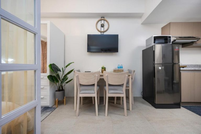 Cocina y comedor moderno con televisor y refrigerador en LD Cozy Condo Unit near Cebu IT Park