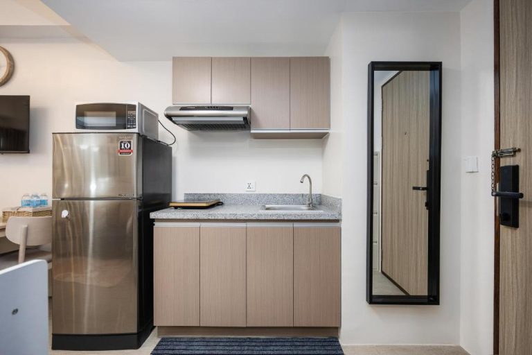 Cocina equipada con refrigerador, microondas y fregadero en LD Cozy Condo cerca de Cebu IT Park