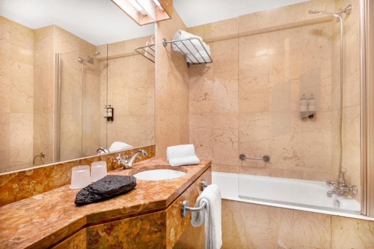 Baño de mármol con bañera y lavabo de la Pousada Forte Horta en las Azores
