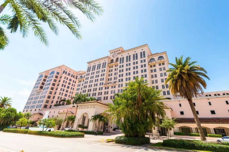Fachada exterior del Hyatt Regency Coral Gables en Miami rodeada de palmeras tropicales