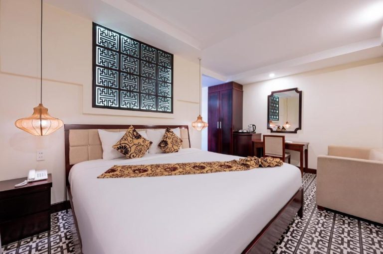 Habitación doble con cama king y decoración tradicional vietnamita en Hoi An Canal House Riverside
