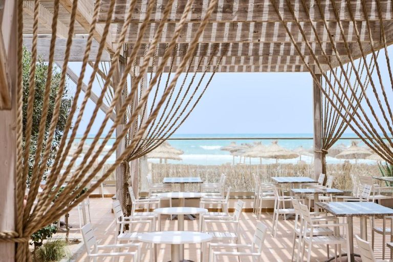 Terraza restaurante frente al mar con mesas blancas y vistas a la playa en Iberostar Waves Mehari Djerba