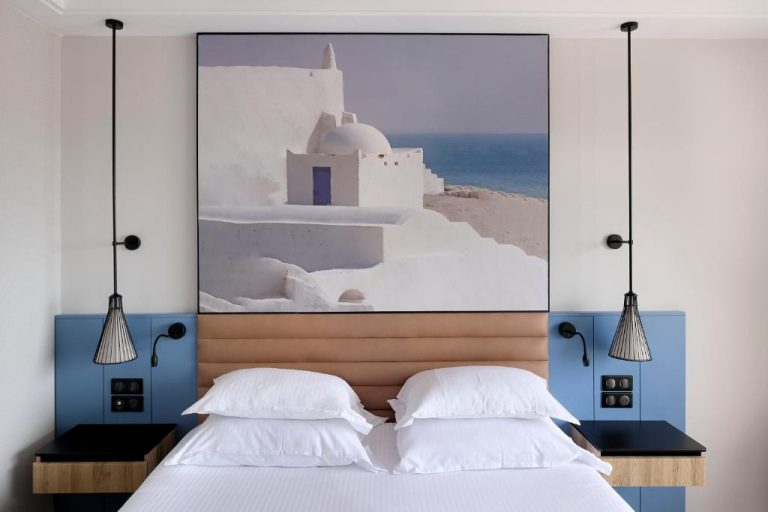 Habitación doble con decoración mediterránea y cuadro de iglesia griega en Iberostar Waves Mehari Djerba