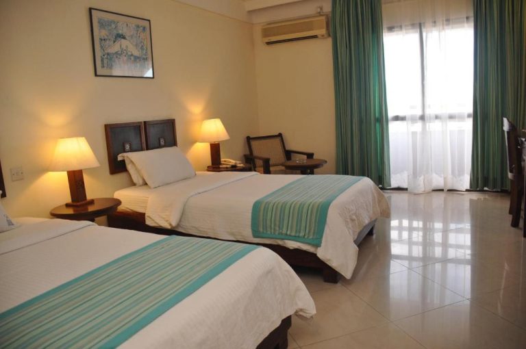 Habitación twin con dos camas y decoración en turquesa del Royal Court Hotel