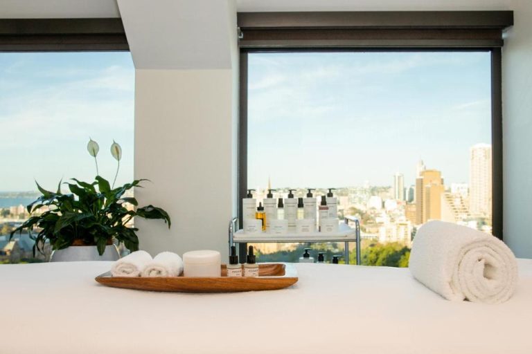 Camilla de spa con productos de belleza y vistas a la ciudad en Sheraton Grand Sydney Hyde Park