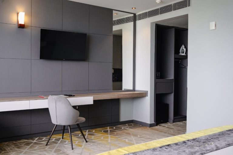 Habitación moderna con escritorio de trabajo y televisión en Manhattan Business Hotel de Male