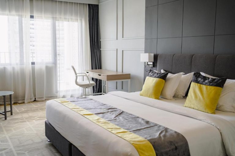 Habitación deluxe con cama king size y decoración en gris y amarillo en Manhattan Business Hotel Male