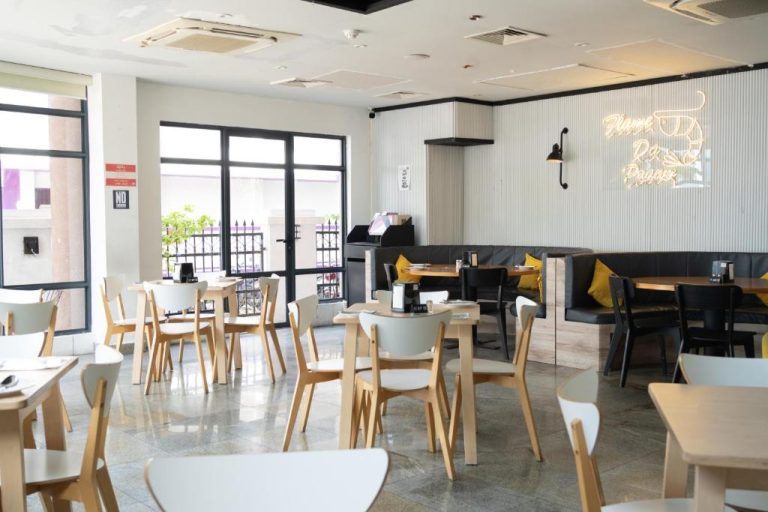 Restaurante interior con mesas y sillones del Manhattan Business Hotel en Malé, Maldivas