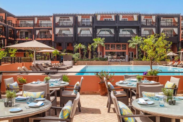 Terraza restaurante con piscina exterior del Hôtel & Ryads Barrière Le Naoura en Marrakech
